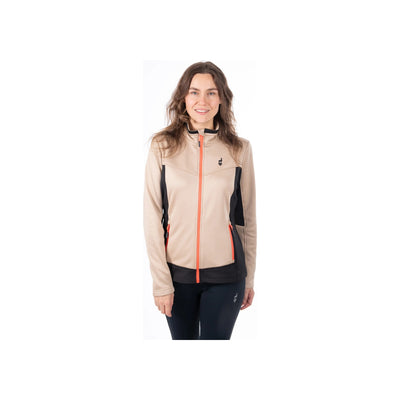 Vrouw draagt beige sportjack met oranje rits en zwarte zijpanelen, zwarte sportbroek, actieve kleding