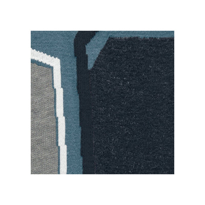 Close-up van een gekleurd tapijt met abstracte vormen in blauw, grijs en wit
