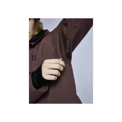 Bruine softshell jas met ritszak op de mouw, close-up van functioneel detail