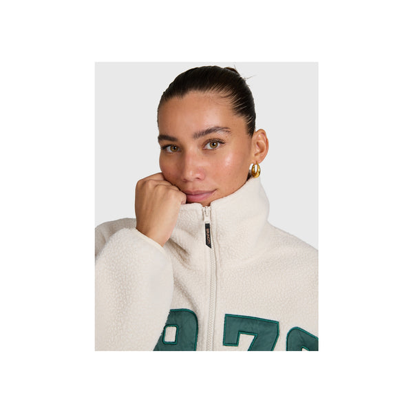 Vrouw draagt witte fleece trui met hoge kraag en rits, close-up portret