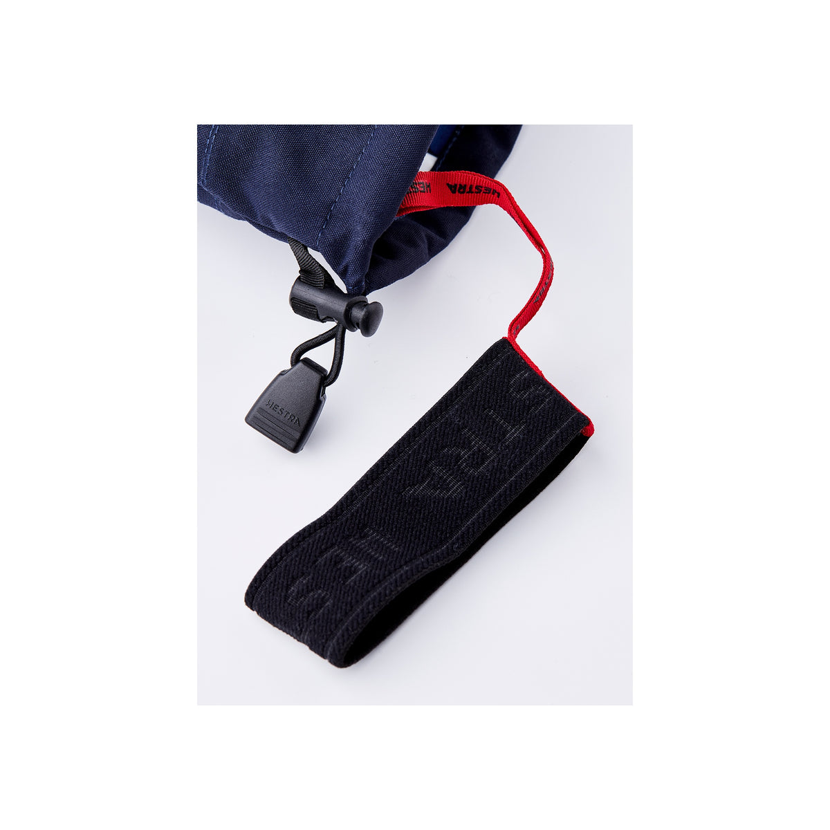 Zwart textiellabel met rode koord bevestigd aan marineblauwe stof met plastic clip