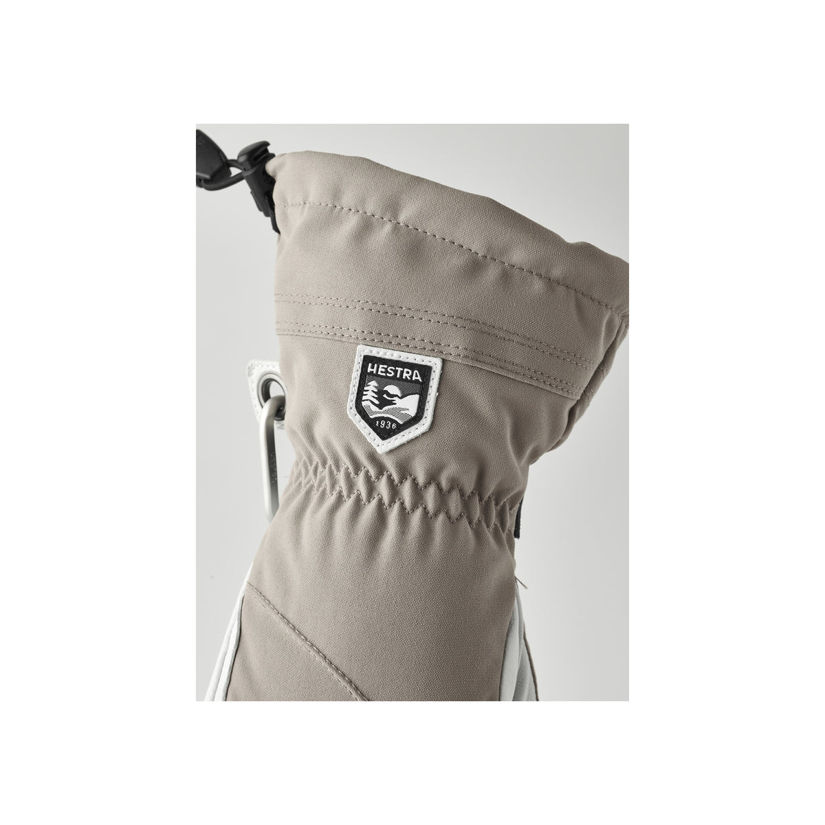 Hestra wintersport handschoen met logo badge en elastische polsband in beige kleur, close-up detail