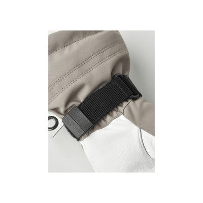 Zwarte klikgesp met verstelbare band op beige jas - veilige sluiting voor outdoor kleding