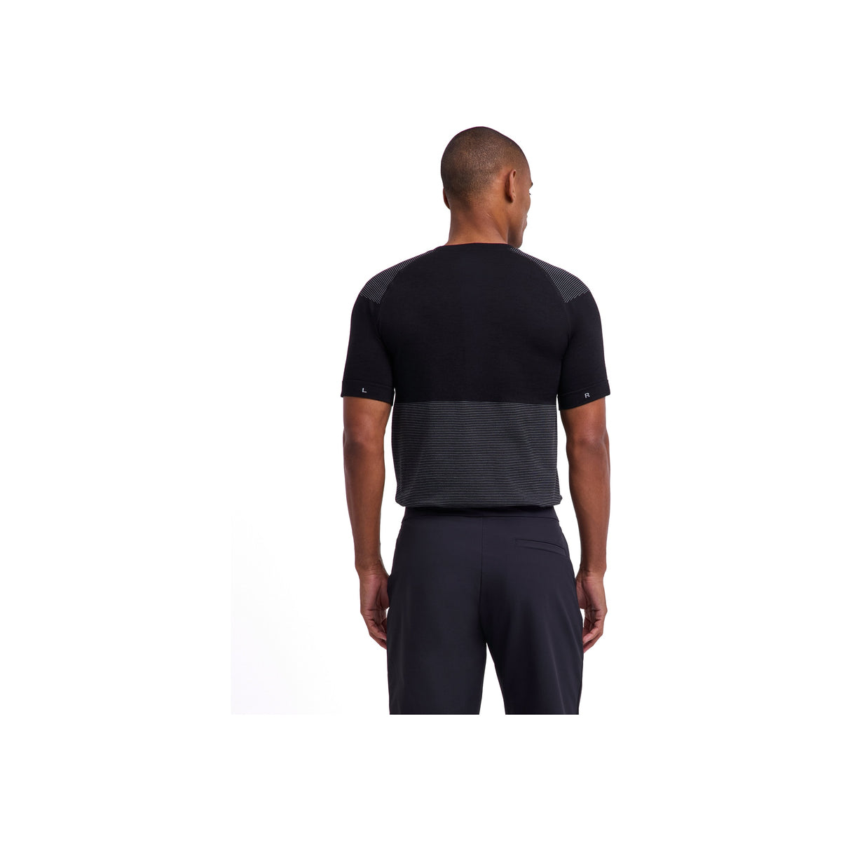 Achterzijde van man met zwart compressie shirt en rugondersteuningsgordel voor training en herstel