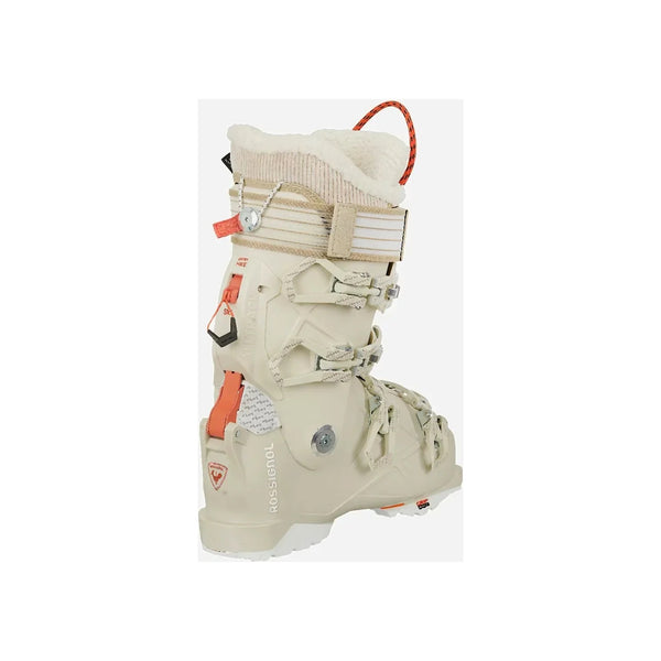 Witte ski-boot met oranje accenten en gespen, zijaanzicht op witte achtergrond