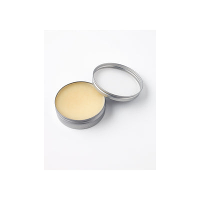 Open blik met gele of beige crème, zalf of balsem in aluminium verpakking op witte achtergrond