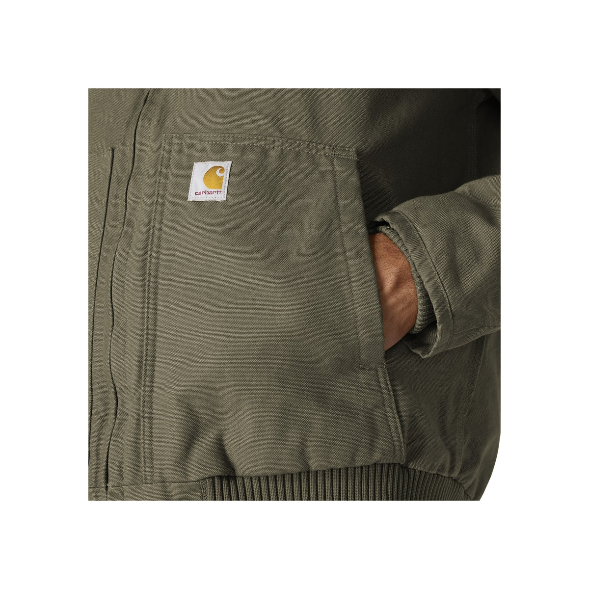 Close-up van Carhartt jas met logo label en ritszak, hand in zak
