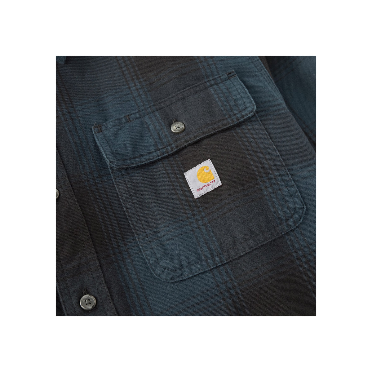 Close-up van Carhartt borstvakken met logo label op blauw werkoverhemd met drukknoopsluiting