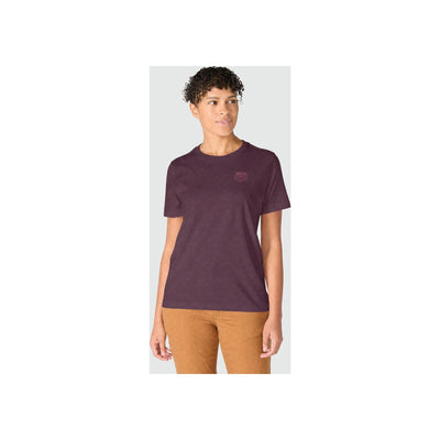 Vrouw draagt paars T-shirt met korte mouwen en ronde hals, gecombineerd met bruine broek