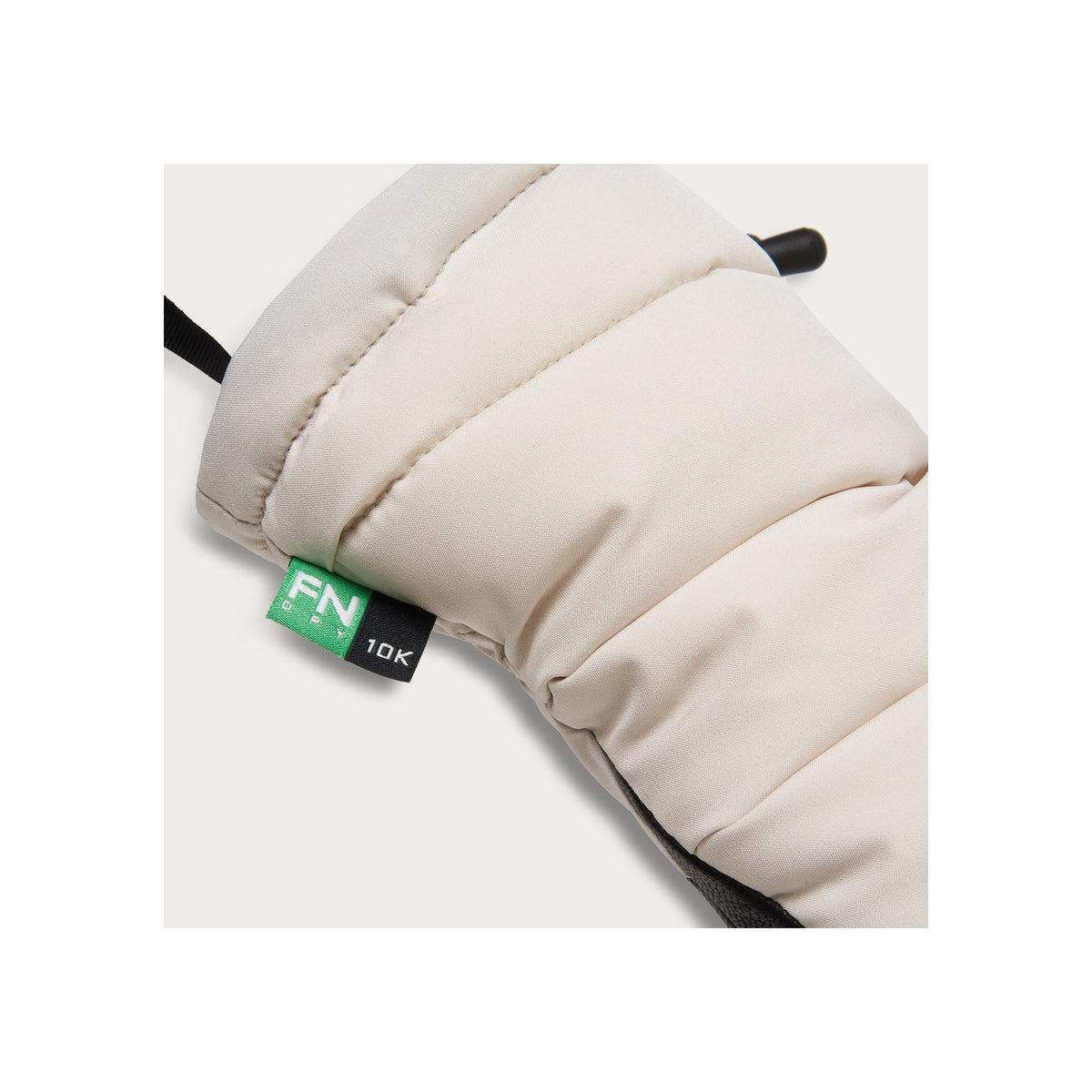 Beige gewatteerde handwarmte handschoen met groene label, close-up detail van gestikt design