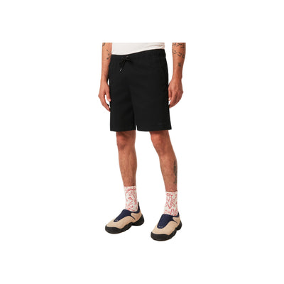 Man draagt zwarte korte broek met trekkoord en witte gestikte sokken met sandalen