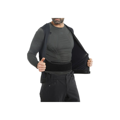 Man toont kogelvrij vest onder zwart jasje met duimen omhoog, tactische beschermende kleding